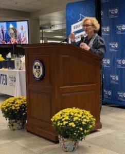Dr. Kurtinitis stands behind a podium in front of a banner celebrating United Way.